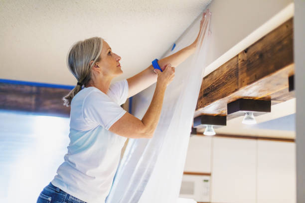 Adult Female Using Painter's Tape and Plastic for Painting Preparation In Western Colorado Adult Female Using Painter's Tape and Plastic for Painting Preparation; Private Residence Remodel and Updates Photo Series with Matching 4K Video Available (Shot with Canon 5DS 50.6mp photos professionally retouched - Lightroom / Photoshop - original size 5792 x 8688 downsampled as needed for clarity and select focus used for dramatic effect) shaping room stock pictures, royalty-free photos & images