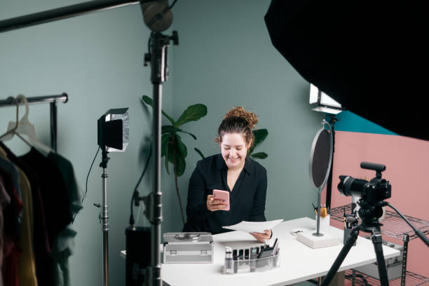 istock Female vlogger looking at mobile phone and smiling 1279047890