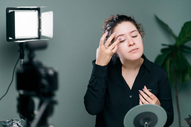 istock Female vlogger applying eye shadow in front of mirror 1279047952