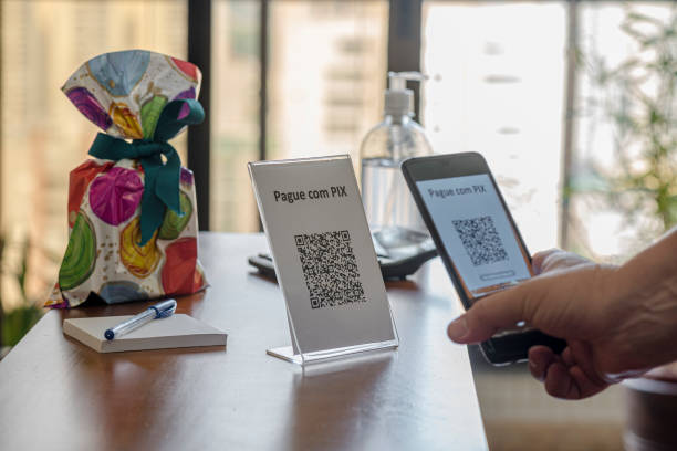 istock Hand holding cell phone with QR Code for payment at the store with new Instant Payment modality - “PIX” 1279049559