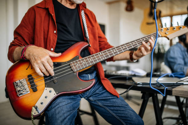 istock Man playing bass guitar at home 1279051203