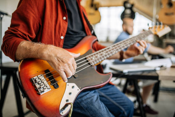 istock Man playing bass guitar at home 1279051225