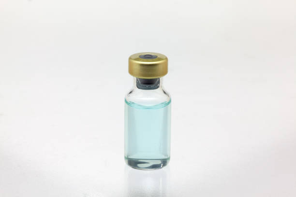 istock Isolated glass vaccine bottle with colored liquid very close high magnification mockup 1279053027