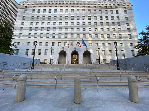 Los Angeles, CA, Jul 2020: wide view entrance to Hall of Justice with flags flying outside in Civic Center district, Downtown