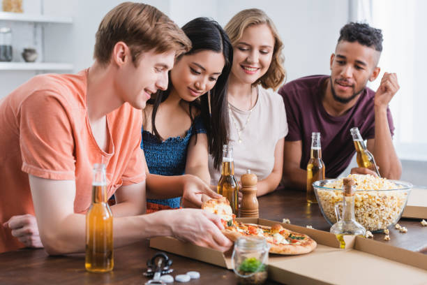 istock joyful multicultural friends taking pizza from box during party 1279054783