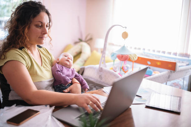 istock Young Mother Is Working On Her Computer While She Is Taking Care For Her Baby Boy 1279059529