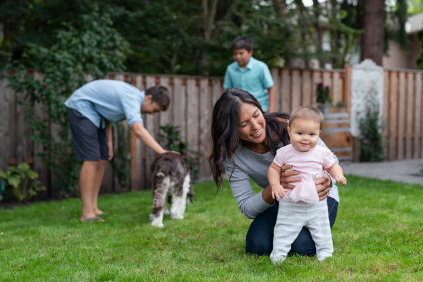 belle mère eurasienne enseignant sa petite fille à marcher - hawaiian ethnicity photos et images de collection