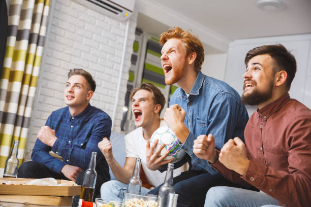 istock Men watching sport on tv together at home shouting happy 1279059657