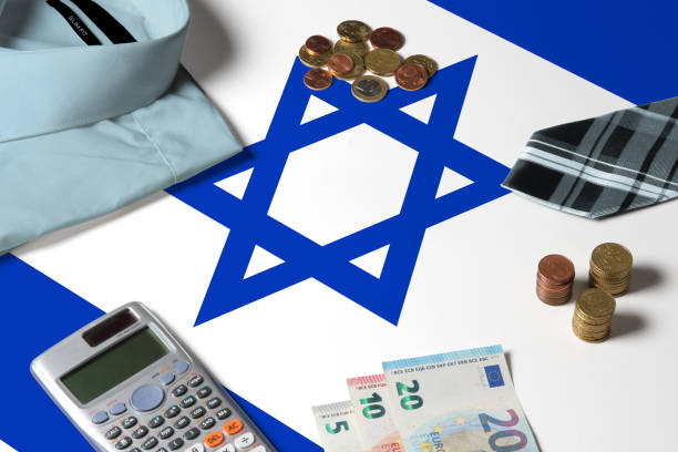 istock Israel flag on minimal money concept table. Coins and financial objects on flag surface. National economy theme. 1279059859