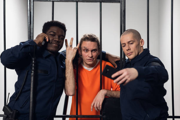 istock Warders in a high-security prison mock a prisoner in a cell, take photos with him on a smartphone 1279065969