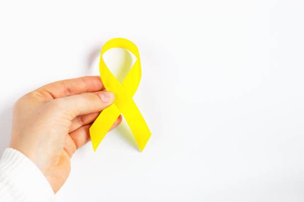 istock Female hands hold yellow ribbon on white background top view 1279067025