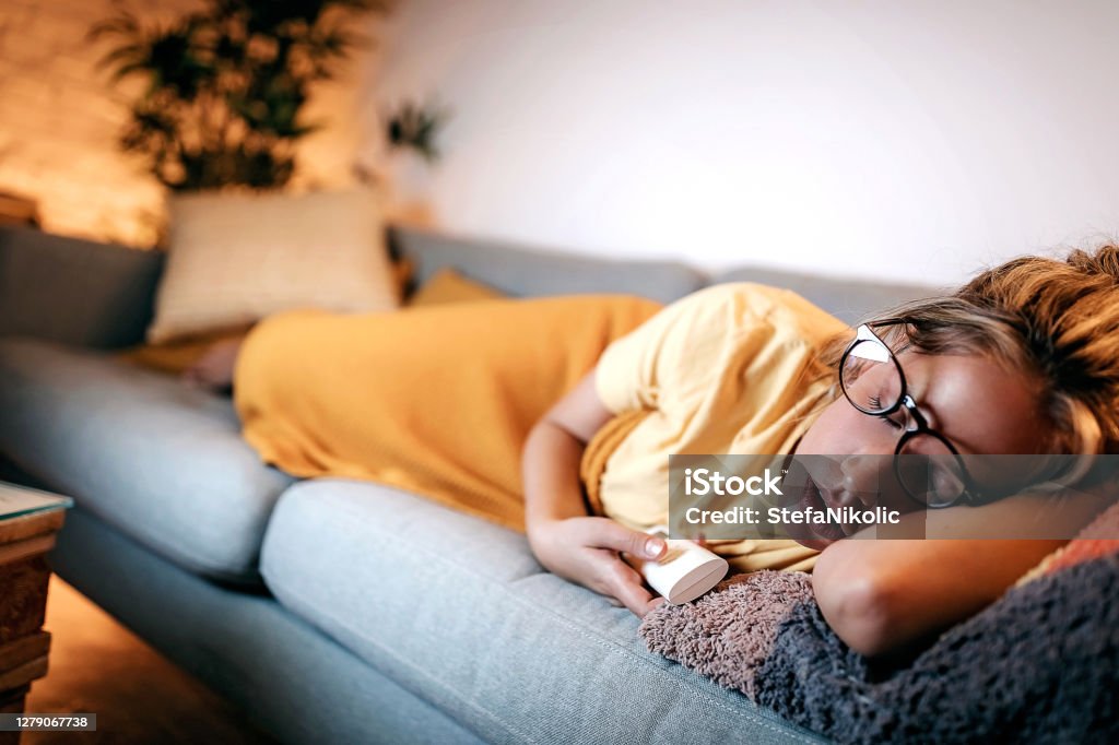 I was so tired Women fall asleep while watching tv Sleeping Stock Photo