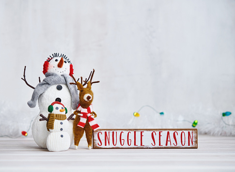 Cute Christmas Background with Snowmen and Reindeer and Snuggle Season Sign