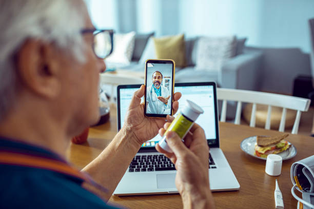 Online Doctor Consultation Close up of a senior man consulting with a doctor on his phone blood pressure medication stock pictures, royalty-free photos & images
