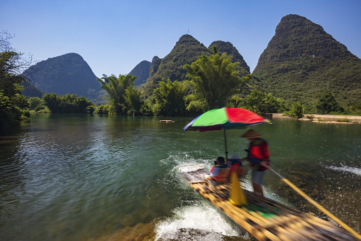 Bamboo rafting in the Yulong River surrounded by dramatic landscape of limestone karst.