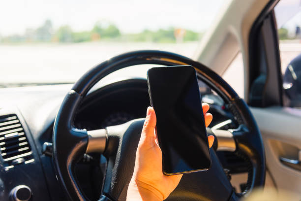 istock Asian woman inside a car and using a hand holding mobile smartphone blank screen while driving the car in the morning during going to work on highway, Transportation and vehicle concept 1279082658