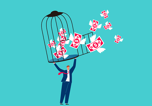 Businessman holding open cage with money flying out, concept of financial freedom and loss
