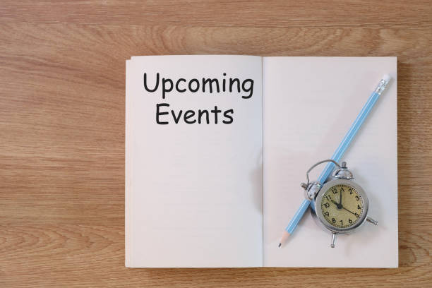 istock Concept Upcoming Events message on notebook with clock and pencil on wooden table. 1279089496