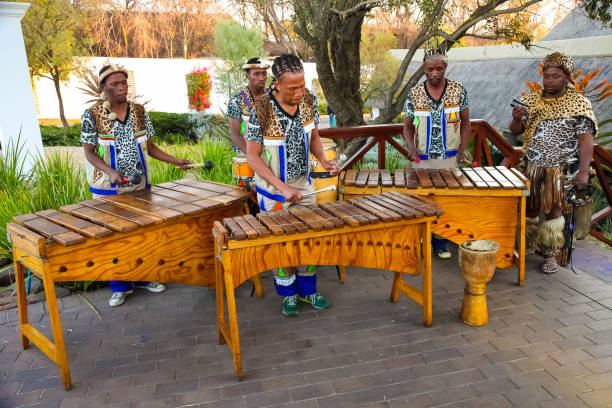 uomini africani che suonano tamburi tradizionali per i turisti - african descent african culture drum history foto e immagini stock