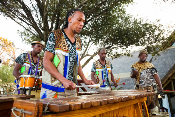 uomini africani che suonano tamburi tradizionali per i turisti - african descent african culture drum history foto e immagini stock