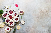 Plate with Christmas or New Year shortcrust cookies with red jam. Traditional festive Austrian cookies with jam. Linzer cookies. Top view.