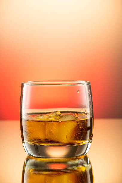 istock whiskey with ice splash in a glass on a colored gradient background 1279097574