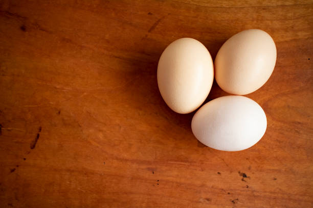 istock Three fresh and organic white eggs on a wooden table. 1279098930