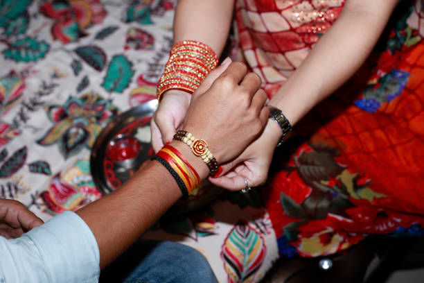 Sister tying Rakhi on brother’s wrist stock photo