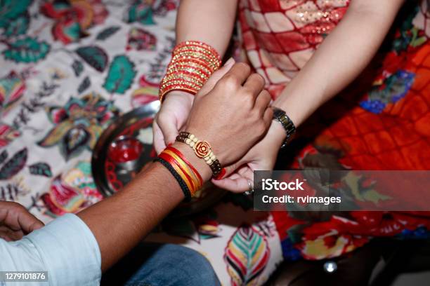 Sister Tying Rakhi On Brothers Wrist Stock Photo - Download Image Now - Raksha Bandhan, Rakhi, Tying