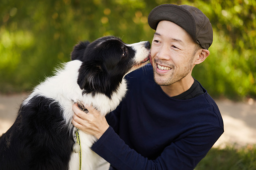 A Japanese man living in Kyoto is having a wonderful time with her dog, a border collie, during a walk.\n\nThe dog expresses affection.