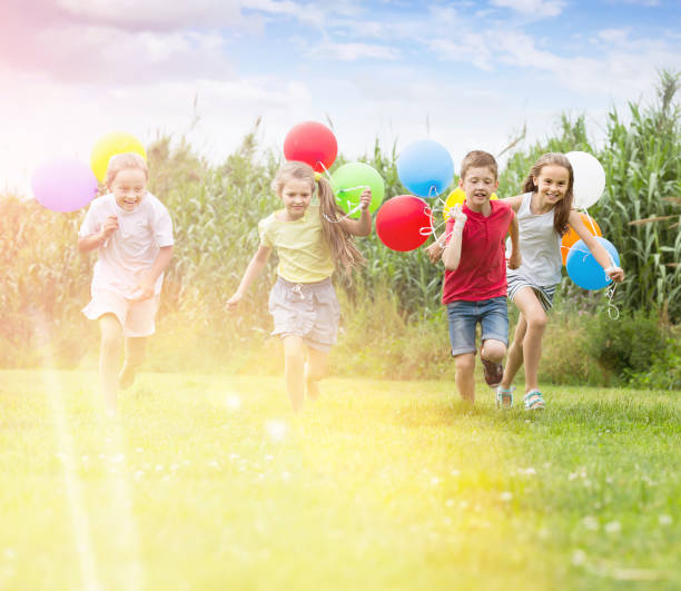istock Four happy kids running on green lawn 1279103177