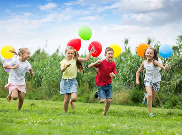 istock children running with air balloons in park 1279103182