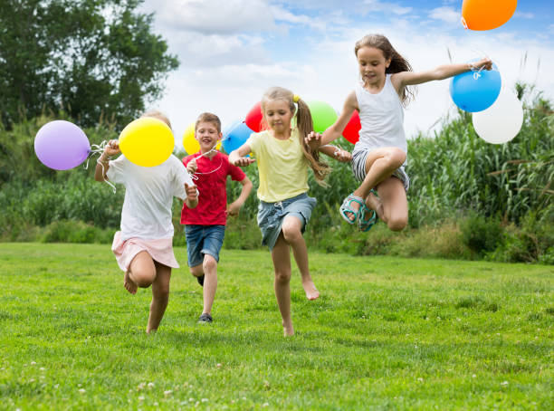 istock children running with air balloons in park 1279103186