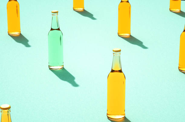 Several glass beer bottles with shadows on light blue background.