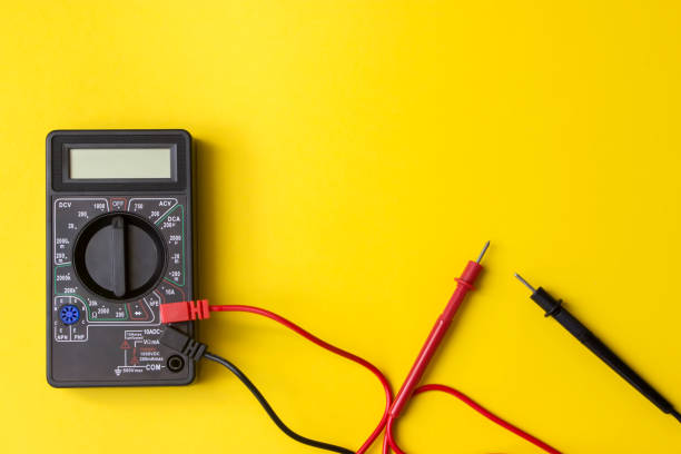istock Digital multimeter with probes and backlit display on a yellow background. A multimeter or a multitester is an electronic measuring instrument. 1279107976