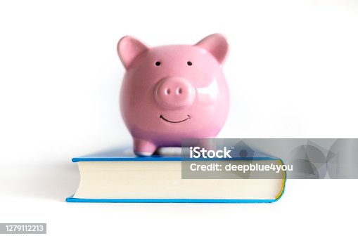istock Pink piggy bank on a blue book 1279112213
