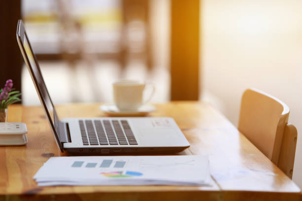 istock Side view, Laptop, graph documents and a cup of coffee on table 1279112407