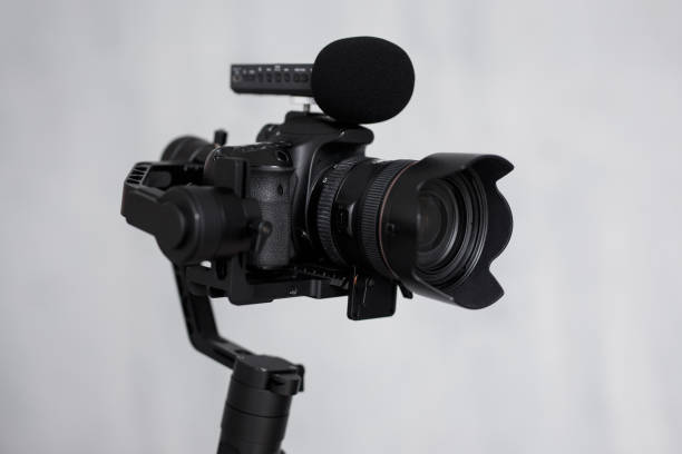istock close up of modern dslr camera on 3-axis gimbal stabilizer with microphone over gray background 1279112960