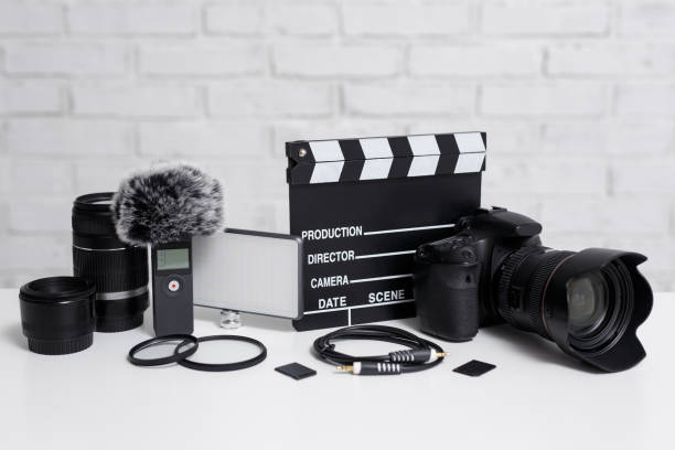 istock videography concept - modern dslr camera, lenses, microphone, led light, clapper board and other videography equipment over white brick wall 1279112973