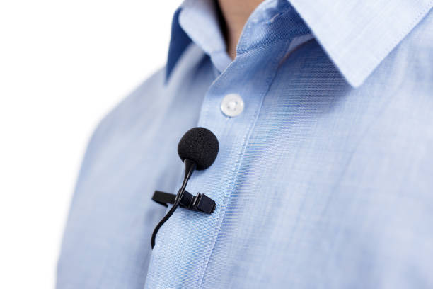 sound recording concept - close up of small lavalier clip-on microphone on male shirt stock photo