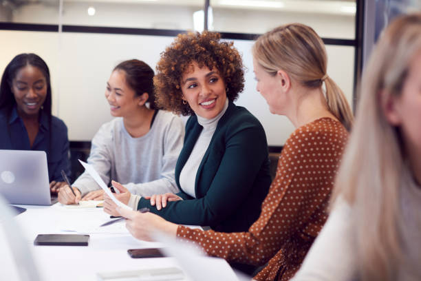 現代オフィスのテーブルの周りの創造的な会議で協力するビジネスウーマンのグループ - 女性のみ ストックフォトと画像
