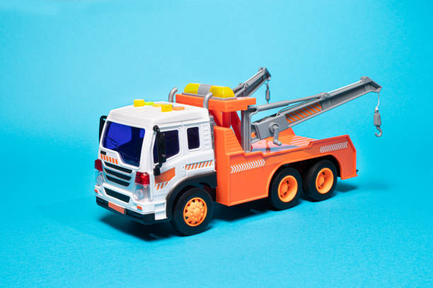 toy orange tow truck on blue background. children's car for loading and transporting cars. copyspace. - tow truck heavy truck delivering imagens e fotografias de stock