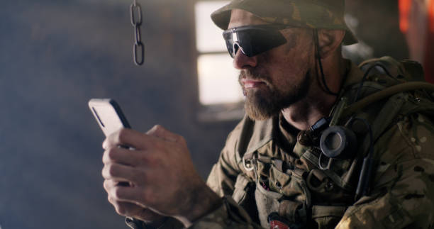 istock Military man using smartphone inside grungy building 1279117634
