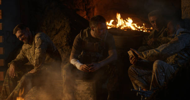 Military men resting around campfire