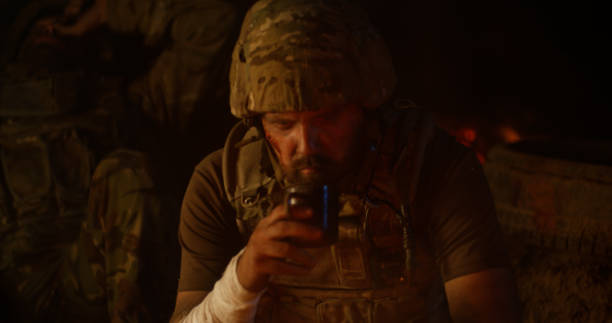 istock Depressed soldier drinking near fire at night 1279118138