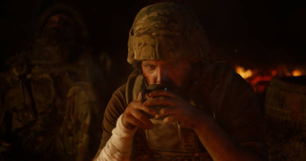 istock Depressed soldier drinking near fire at night 1279118151