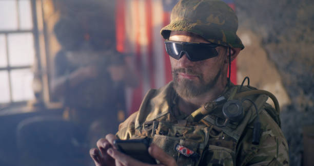 istock Military man using smartphone inside grungy building 1279118156