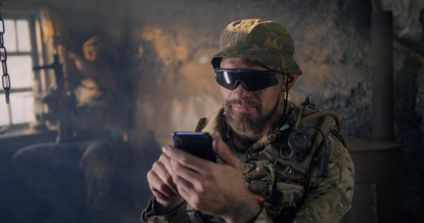 istock Military man using smartphone inside grungy building 1279118227