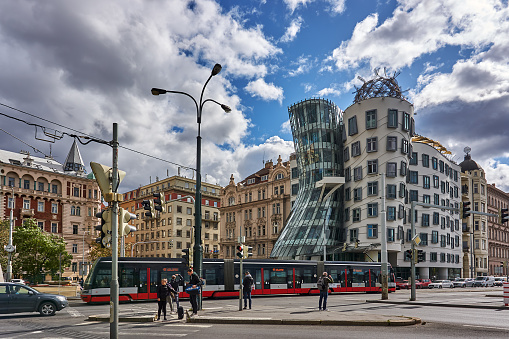 Prague, Czech Republic - September 30, 2019: pedestrians, traffic and a tram on the Rasinovo Nabr. Road. in the background the Dancing House of Prague.