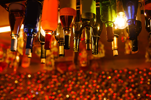 Many inverted bottles hang, close-up shot